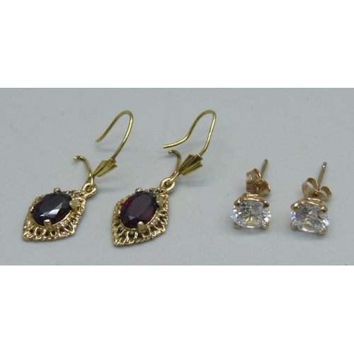 1121 - A pair of 9ct gold and garnet drop earrings, and a pair of yellow metal and white stone stud earring... 