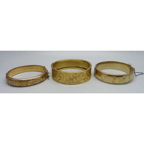 1127 - A rolled gold bangle, a 9ct metal core bangle and a gold plated bangle