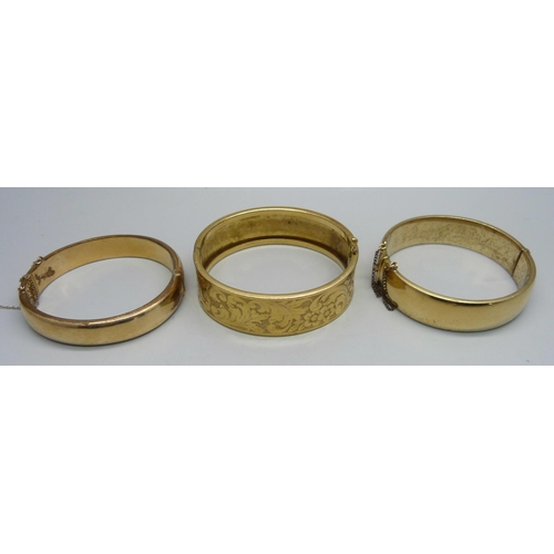 1127 - A rolled gold bangle, a 9ct metal core bangle and a gold plated bangle