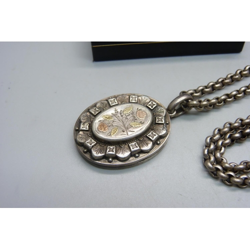 1135 - A Victorian white metal locket with applied gold decoration, on a modern silver belcher chain, toget... 