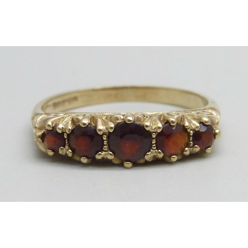 1148 - A 9ct gold ring set with five garnets, 2.4g, O