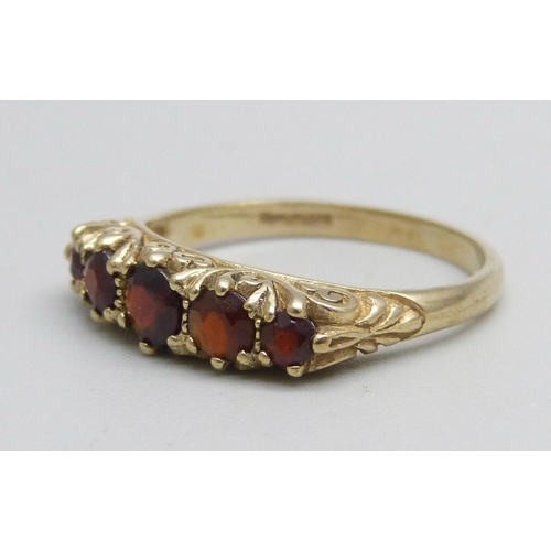 1148 - A 9ct gold ring set with five garnets, 2.4g, O