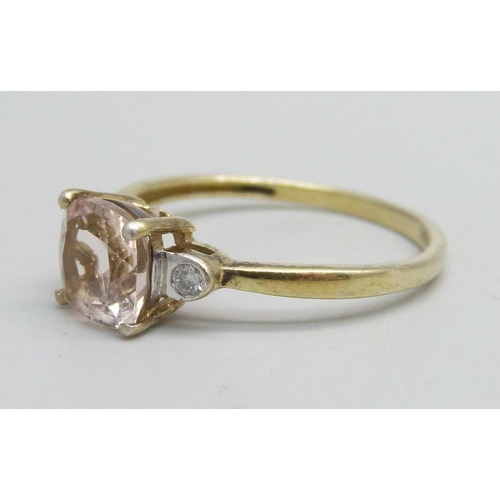 1153 - A silver gilt ring set with a pink stone and two small diamonds, R