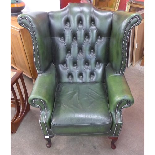 102 - A green leather Chesterfield wingback armchair