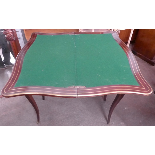 134 - A 19th Century mahogany and brass inlaid serpentine fold over games table