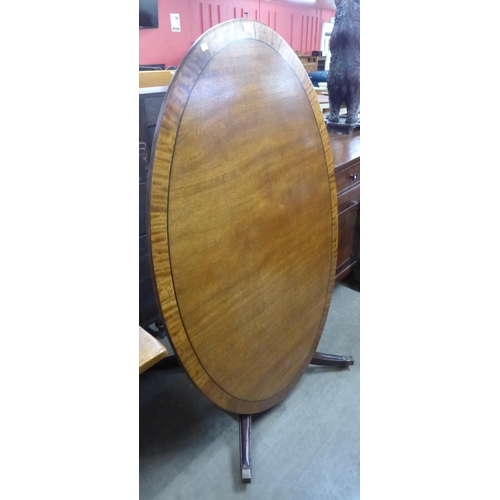 138 - A 19th Century mahogany oval tilt-top dining table, Waites of Chesterfield