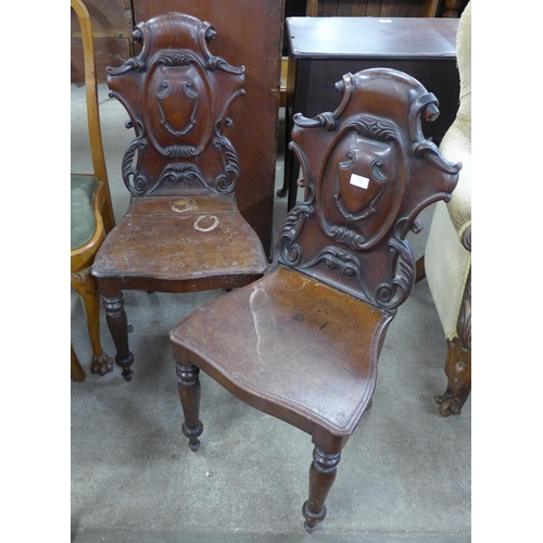 212 - A pair of Victorian carved mahogany hall chairs