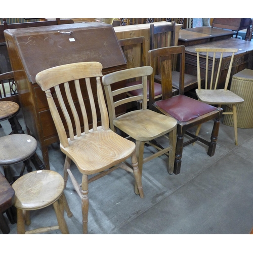 219 - An Ercol Blonde elm and beech chair, two elm seated kitchen chairs, three oak chairs and a bureau