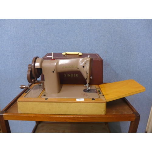 294 - A cased Singer sewing machine, with accessories