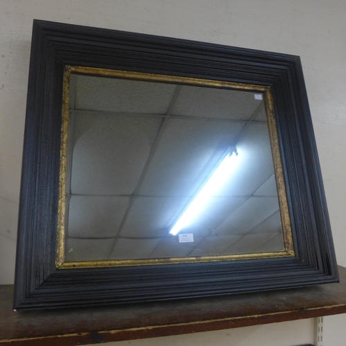 365 - An ebonised and parcel gilt framed mirror