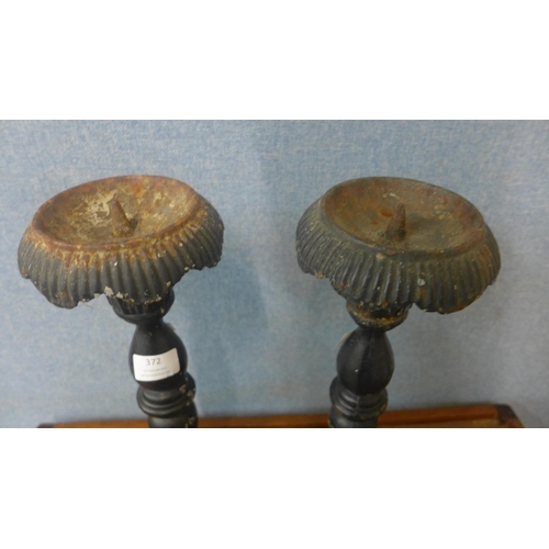 372 - A pair of cast iron ecclesiastical candlesticks