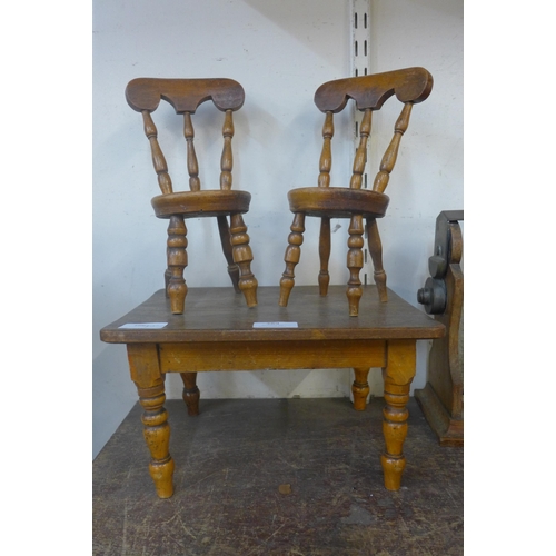 389 - A Victorian style doll's elm kitchen table and two chairs