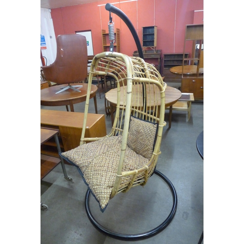 54 - A bamboo hanging chair, on black steel stand