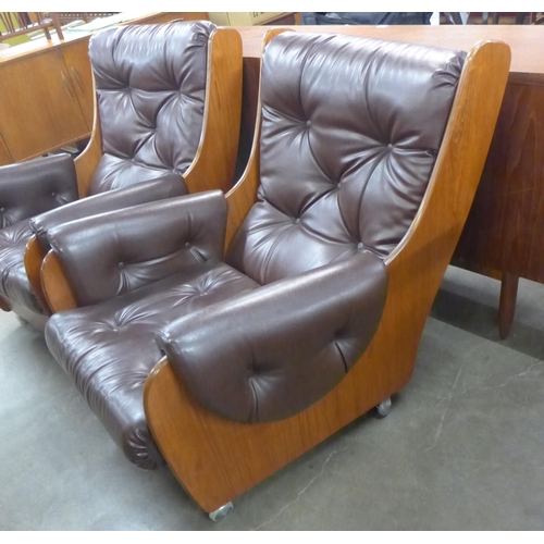 65 - A pair of G-Plan teak and burgundy leather Saddle armchairs. Please note this lot is being sold as a... 