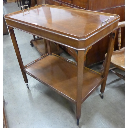 136 - An early 20th Century Chippendale style mahogany and brass handled trolley