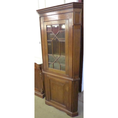 218 - A George III style oak freestanding splay front corner cabinet