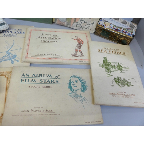 695 - A collection of tea cards, stamps, ephemera and books including Enid Blyton, etc.