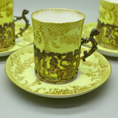 895 - Four Staffordshire 'Eggshell' coffee cans and saucers with four silver holders, William Comyns, Birm... 