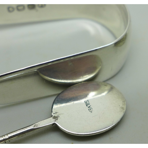 898 - A small silver pill box, two silver spoons and a pair of silver sugar bows, 81g