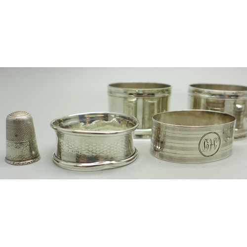 924 - Five silver napkin rings, one a/f, two others and a thimble, weight of silver 57g