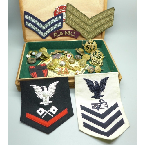 932 - A collection of military items including patches, buttons and cap badges