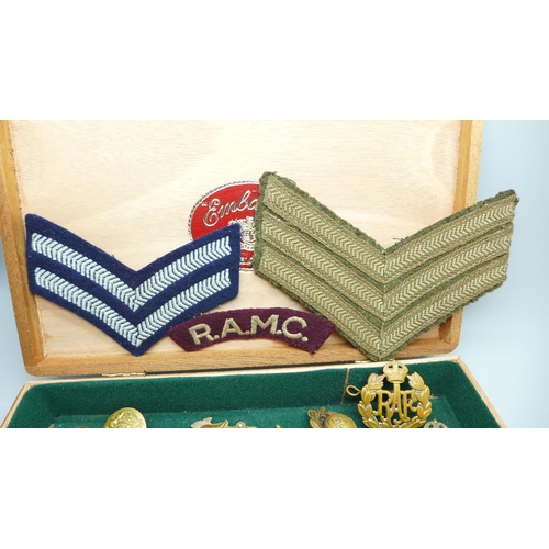 932 - A collection of military items including patches, buttons and cap badges