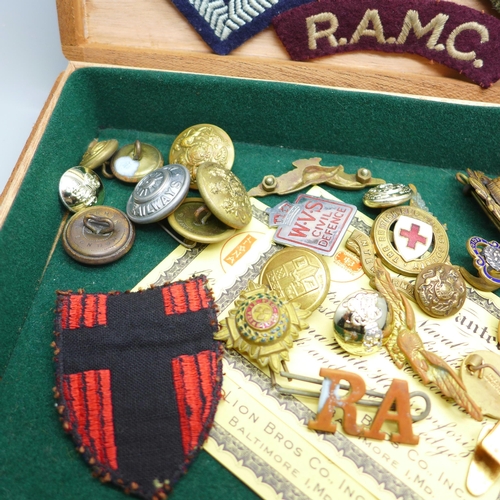 932 - A collection of military items including patches, buttons and cap badges