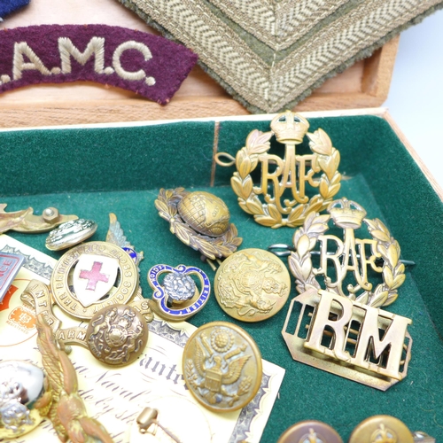 932 - A collection of military items including patches, buttons and cap badges