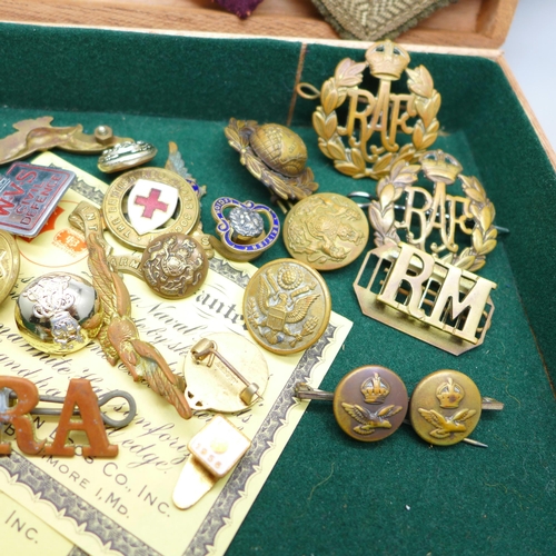 932 - A collection of military items including patches, buttons and cap badges