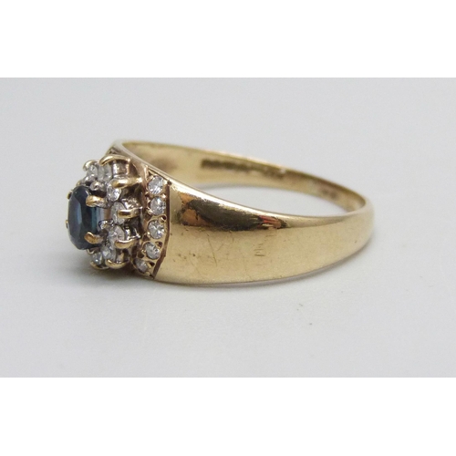 1021 - A 9ct gold, diamond and sapphire ring set with 20 diamonds and a central sapphire, 1.7g, M