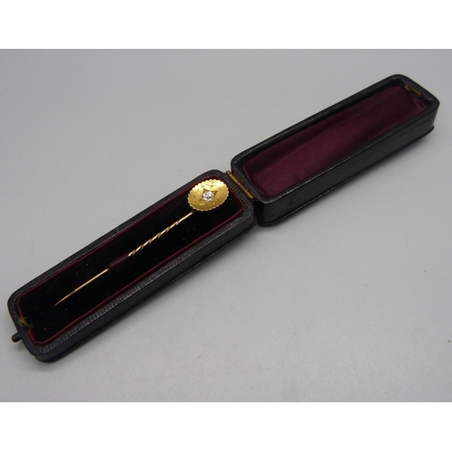 1024 - A yellow metal stick pin set with a diamond, 2.6g, cased