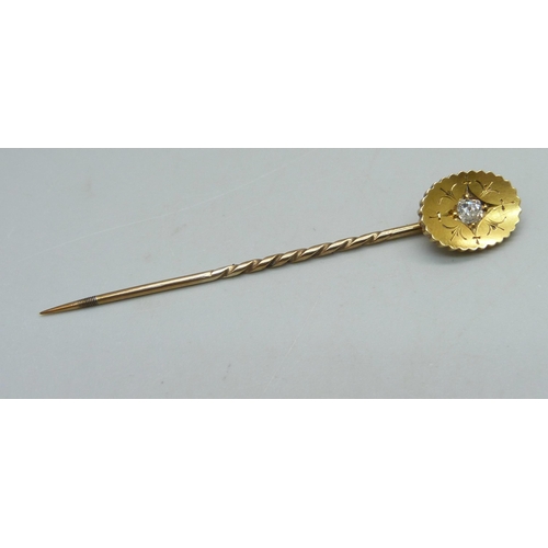 1024 - A yellow metal stick pin set with a diamond, 2.6g, cased