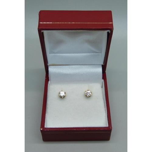 1029 - A pair of 18ct gold and diamond stud earrings, total 0.60 carats, 1.3g