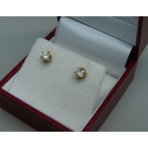 1029 - A pair of 18ct gold and diamond stud earrings, total 0.60 carats, 1.3g