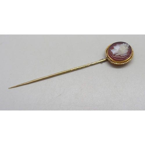 1034 - A yellow metal and carved cameo stick pin, 3.7g, cased