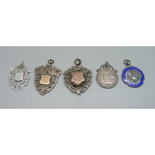 1073 - Four silver fobs including one enamelled example, and a white metal mounted coin pendant, loop a/f, ... 