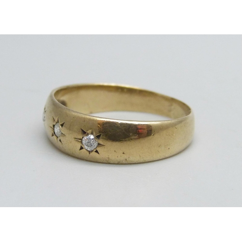 1092 - A 9ct gold ring set with three diamonds, 2.7g, R