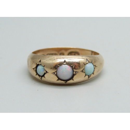 1097 - A 9ct gold ring set with three opals, 1.4g, M, some dents to shank