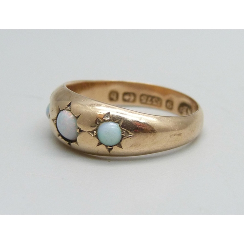 1097 - A 9ct gold ring set with three opals, 1.4g, M, some dents to shank