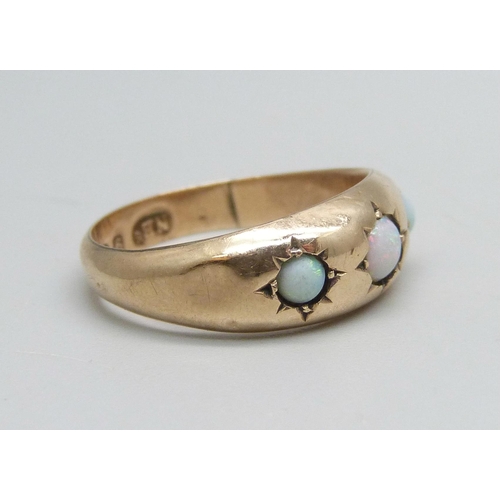 1097 - A 9ct gold ring set with three opals, 1.4g, M, some dents to shank