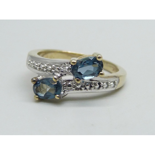 1131 - A silver gilt London blue topaz cross over ring, N