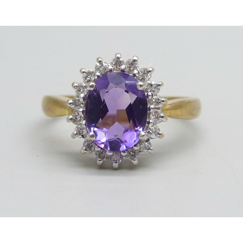 1135 - An 18ct gold ring set with an amethyst and diamond halo, 4.5g, Q