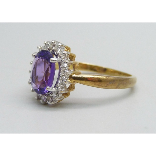 1135 - An 18ct gold ring set with an amethyst and diamond halo, 4.5g, Q