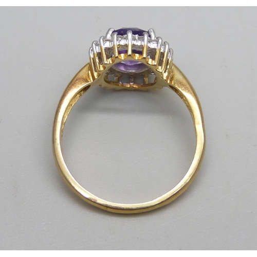 1135 - An 18ct gold ring set with an amethyst and diamond halo, 4.5g, Q