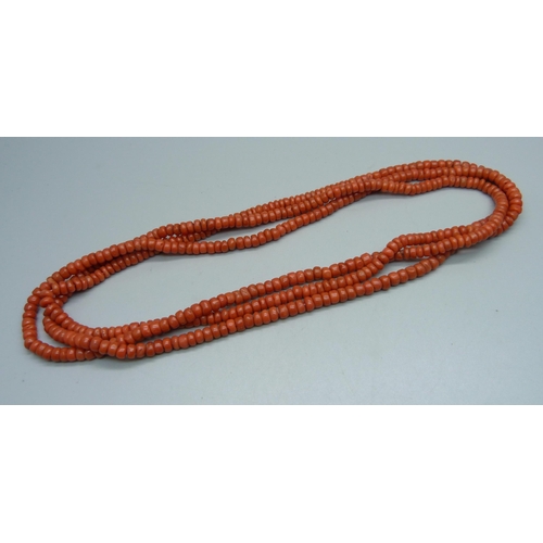 1144 - A coral long guard chain, approximately 144cm