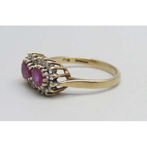 986 - A 9ct gold ring set with two rubies and an outer row of diamonds, 2.3g, N