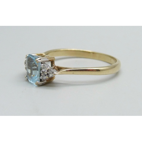 987 - A 9ct gold ring set with a blue topaz and white stones, 2.4g, T