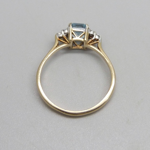 987 - A 9ct gold ring set with a blue topaz and white stones, 2.4g, T