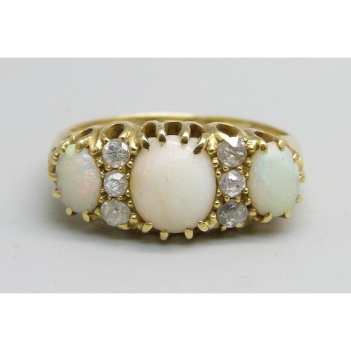 1042 - An 18ct gold three stone opal and diamond ring, 3.2g, M