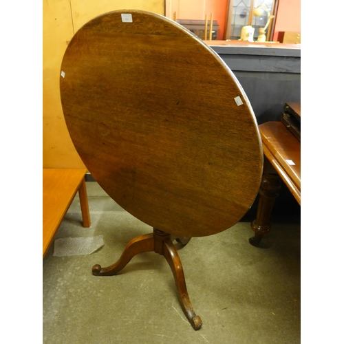 131 - A George III oak circular tilt-top tripod tea table